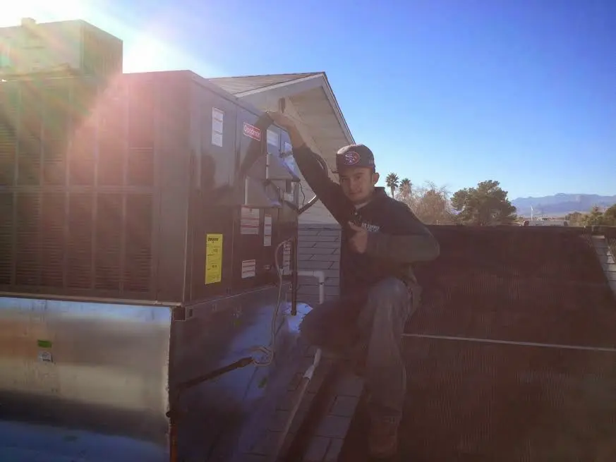 HVAC technician performing HVAC Inspection on a rooftop unit in Groveton